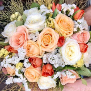 Donna Fugata Bouquet di fiori - dai toni perlati del bianco, arancio e pesca: Peach Avalanche+, Pearl Avalanche+, Avalanche+ , tulipani arancio, Statice Limonio Limonium bianco e giallo, accuratamente confezionato con verde decorativo di stagione.