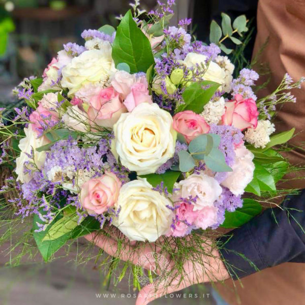 Donna Rosaria Bouquet di fiori - dai toni eleganti e delicati: Rose Avalanche+, Lisianthus rosa e bianco, Statice Limonio Limonium lilla e buanco, accuratamente confezionato con verde decorativo di stagione.